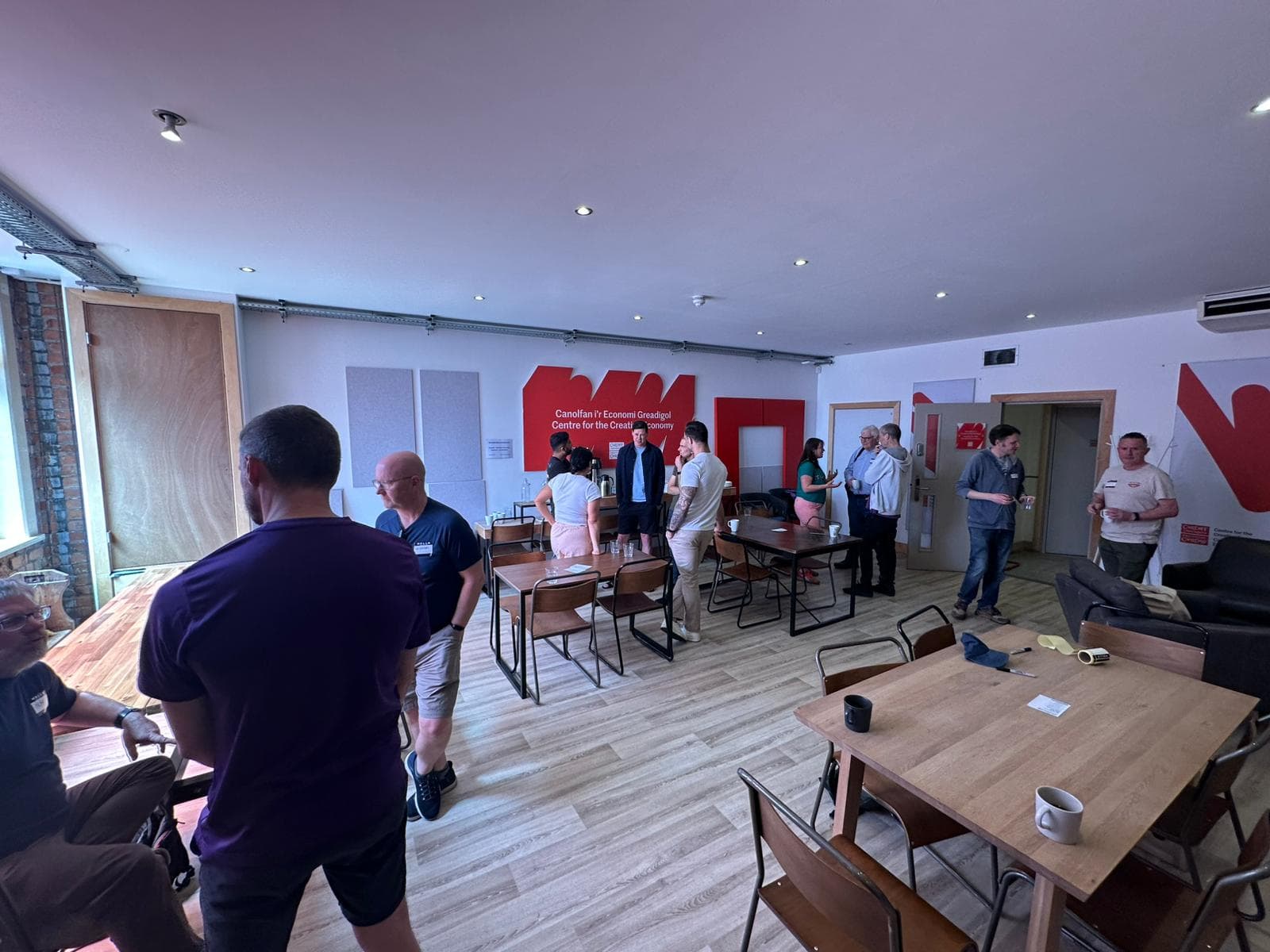 Overview of AI Wales Latte Lounge networking event with attendees mingling
